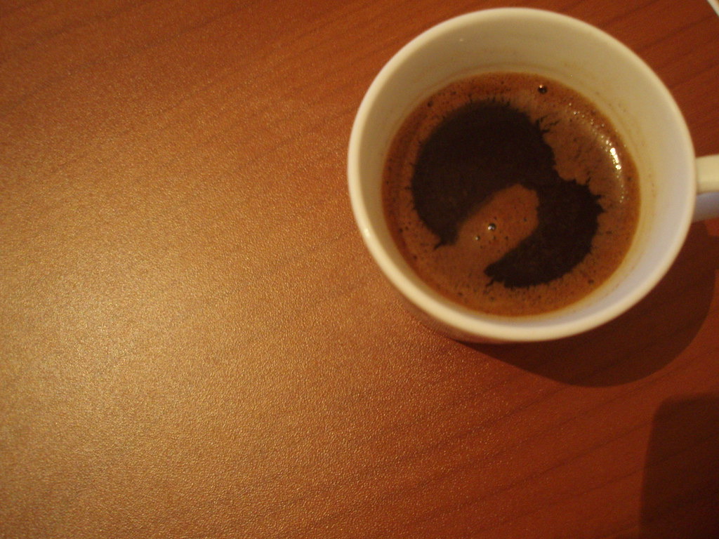 A small cup of Greek coffee on a café table.
