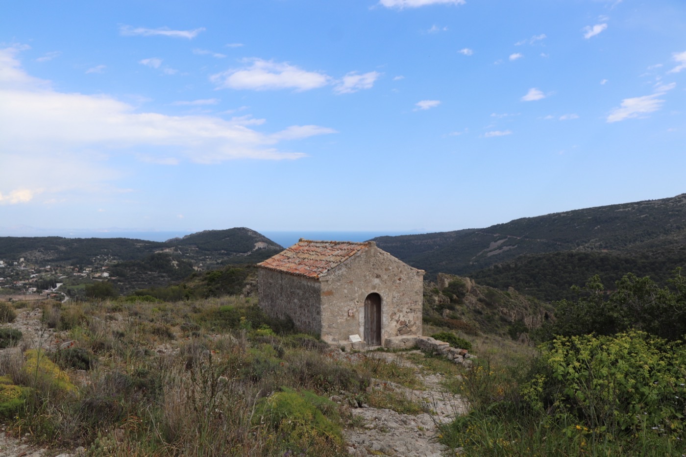 A whitewashed Byzantine chapel on the Paleochora hillside in early light.