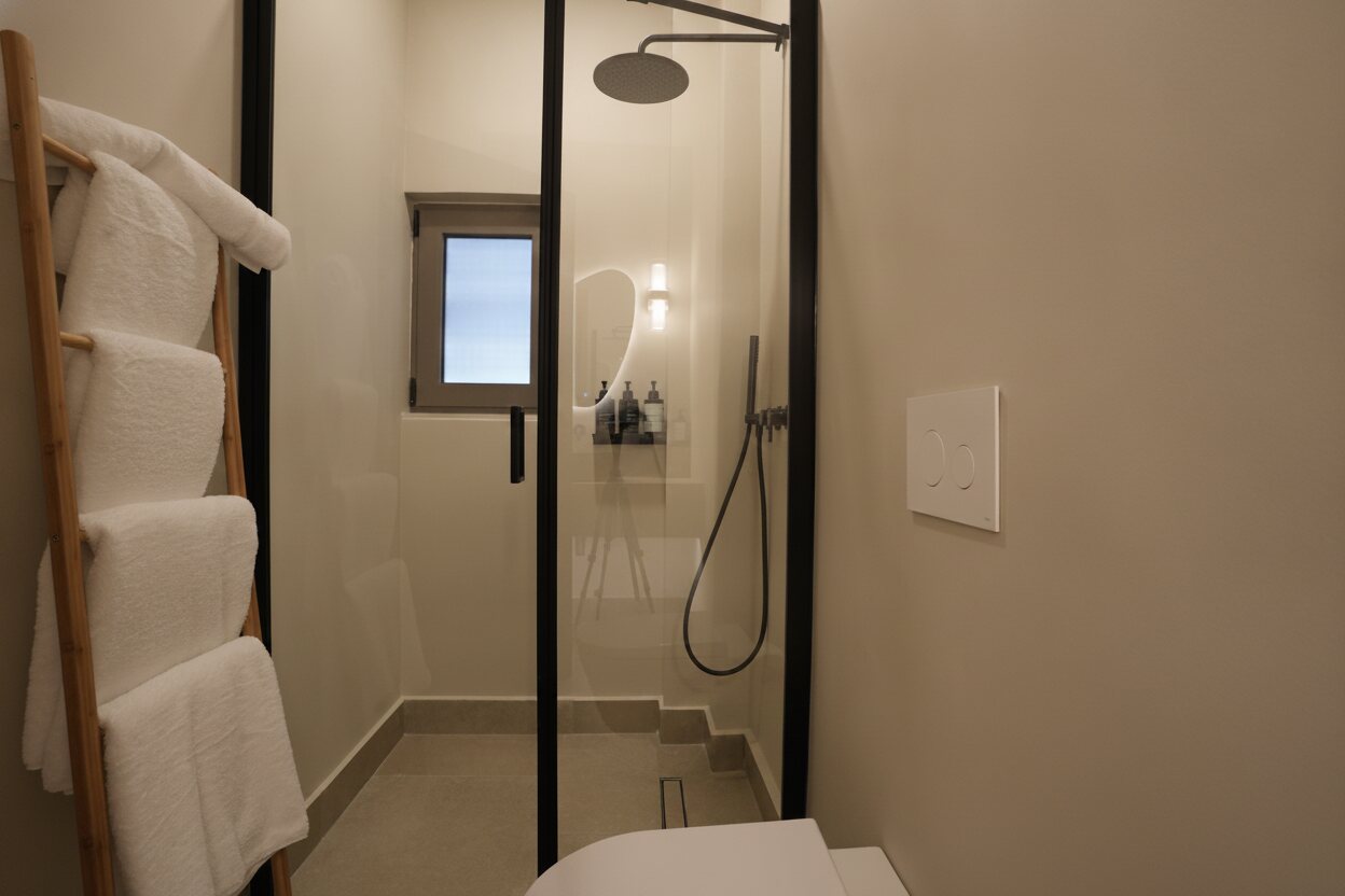 The bath — terrazzo, brass, a walk-in shower